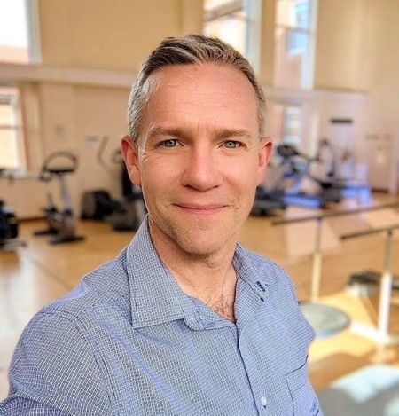 Selfie of a man smiling wear a blue checked shirt 