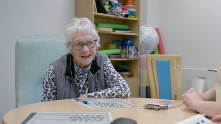 A patient sat at a table in a ward day room.