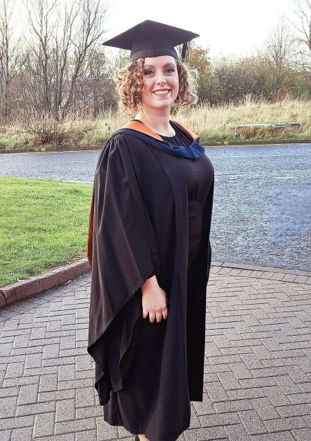 Photo of a woman smiling at a graduation ceremony