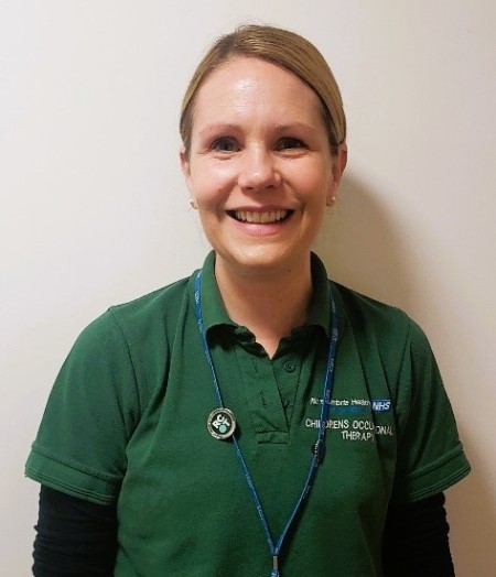 Photograph of a lady wearing a green polo smiling 