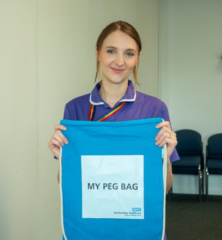 A nurse holding one of the PEG grab bags.